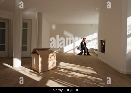 Femme assise sur une chaise dans la salle vide Banque D'Images