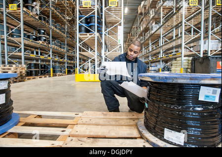 Male warehouse worker checking afin de palettes Banque D'Images