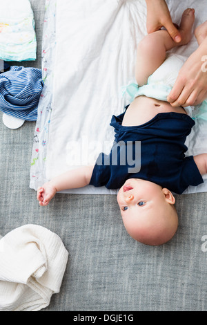 Personne qui change la couche bébé garçon, overhead view Banque D'Images