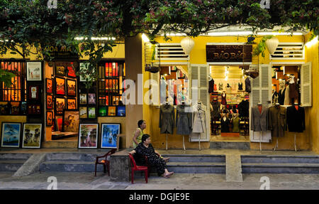 Scène de rue, deux femmes devant une boutique de tailleur, Hoi An, Vietnam, Southeast Asia Banque D'Images