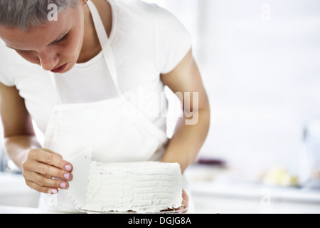 Woman decorating cake Banque D'Images