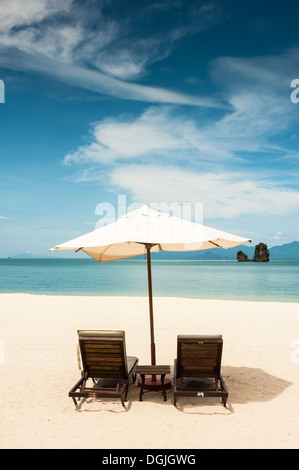 Deux chaises longues et un parasol sur la plage de Tanjung Rhu à Langkawi. Banque D'Images