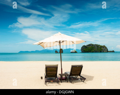 Deux chaises longues et un parasol sur la plage de Tanjung Rhu à Langkawi. Banque D'Images