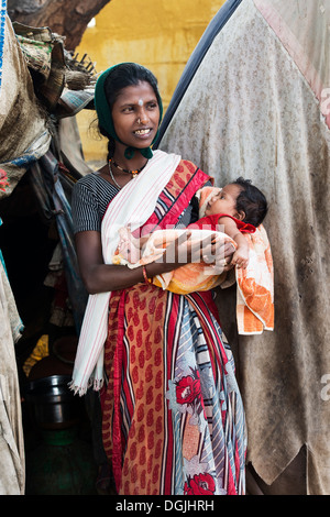 Basse caste indienne avec son bébé debout devant sa bender / tente / logement. L'Andhra Pradesh, Inde Banque D'Images