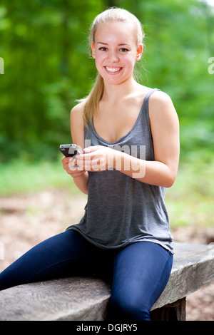 Berlin, Allemagne, Portrait d'une jeune femme à l'aide de son téléphone portable Banque D'Images