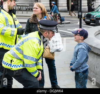 Un jeune garçon parlant à un agent de la Police métropolitaine. Banque D'Images