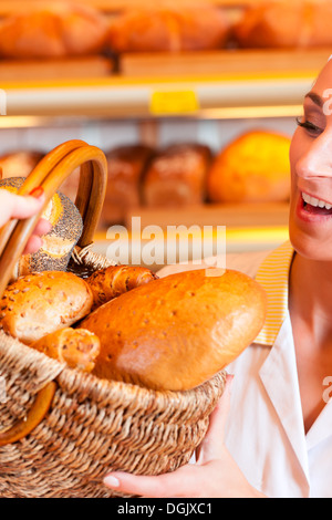 Femme Baker ou vendeuse en boulangerie avec son client une femelle et des pâtisseries ou produits de boulangerie Banque D'Images