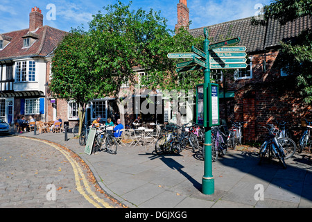 Les visiteurs appréciant le soleil d'automne dans la rue café près À St William's College York North Yorkshire Angleterre United Royaume-Uni Grande-Bretagne Banque D'Images