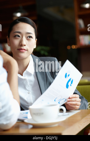 Un homme d'affaires et d'une business woman talking at a table Banque D'Images