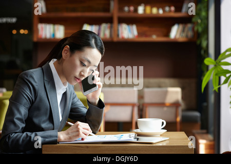 Une femme d'affaires assis à une table de café Banque D'Images