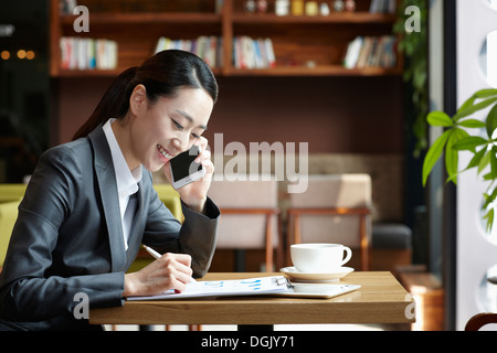 Une femme d'affaires assis à une table de café Banque D'Images