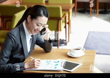 Une femme d'affaires assis à une table de café Banque D'Images