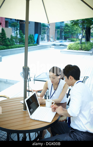 Un homme et une femme travaillant avec des ordinateurs portables Banque D'Images