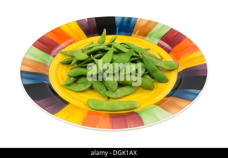 Une portion de gousses de soja Edamame cuites sur une plaque de couleur. Banque D'Images