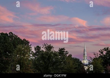 Un clocher blanc pointe vers le haut à travers des nuages colorés au coucher du soleil à Snellville, en Géorgie, juste à l'extérieur d'Atlanta. (ÉTATS-UNIS) Banque D'Images