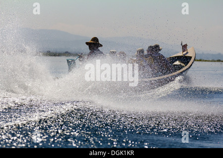 La vitesse d'un bateau de tourisme caché dans spray sur le lac Inle Inle au Myanmar. Banque D'Images