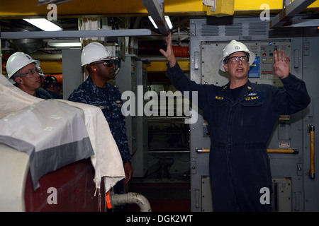 Mécanicien en chef Senior Eric Martin explique les mises à niveau du moteur prévue du navire du commandant du groupe aéronaval expéditionnaire (ESG) Arrière 3 Adm. Frank étang au cours d'une visite à bord d'un quai de transport amphibie USS Green Bay (LPD 20). Green Bay est dans BAE syst Banque D'Images