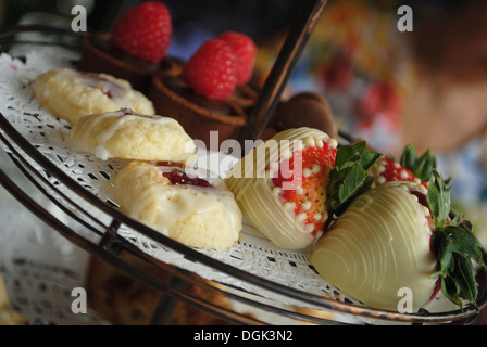 Des fraises au chocolat blanc sur le plateau de service avec d'autres desserts Banque D'Images