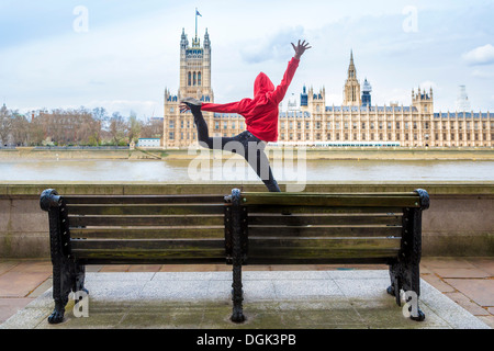 Young male dancer mid air en face du parlement, London, UK Banque D'Images