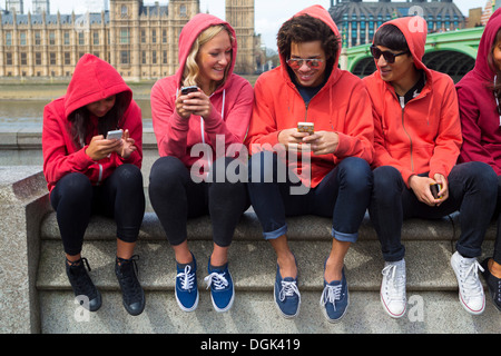 Groupe de jeunes looking at mobile phone Banque D'Images