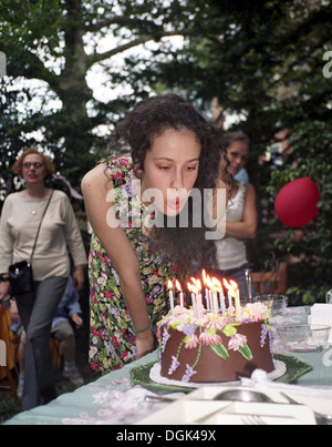 Jeune femme faisant un vœu et souffler les bougies sur son gâteau d'anniversaire 18. M. Banque D'Images