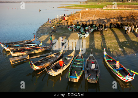 Bateaux de plaisance Tourisme transiter par le pont en teck U Bein sur le lac Taungthaman au Myanmar. Banque D'Images