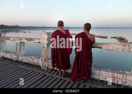 Deux moines bouddhistes, promenade sur le pont en teck U Bein au Myanmar juste après le coucher du soleil. Banque D'Images