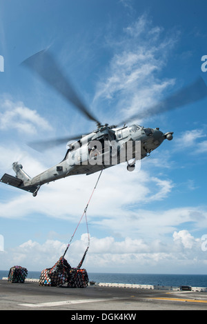 Une Sea Hawk MH-60S abandonne l'hélicoptère cargo dans le poste de pilotage de l'assaut amphibie USS Boxer (DG 4) lors d'un ravitaillement vertical. Boxer est déployée à l'appui d'opérations de sécurité maritime et les efforts de coopération en matière de sécurité dans le théâtre dans le Banque D'Images