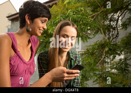 Deux jeunes femmes avec cell phone Banque D'Images