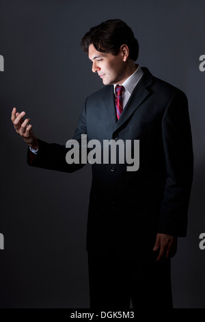 Businessman looking at part comme s'cellphone, éclairé Banque D'Images