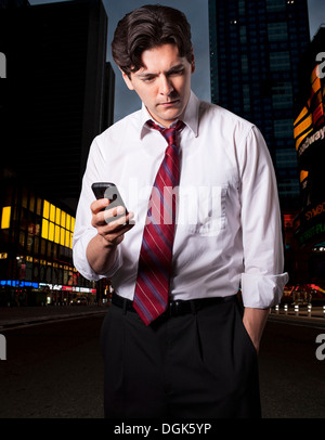 Stressed businessman en ville avec smartphone Banque D'Images
