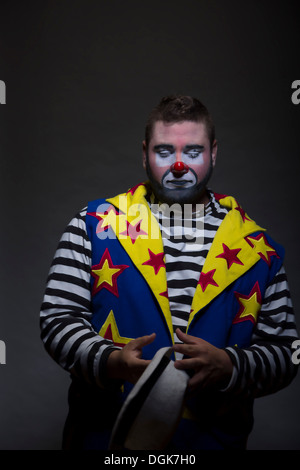 Studio portrait de clown holding hat Banque D'Images