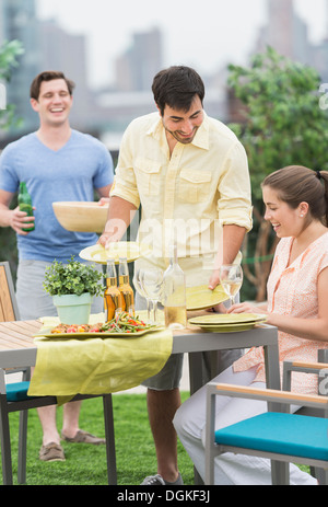 Friends enjoying barbecue in garden Banque D'Images