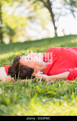 Young woman lying on grass Banque D'Images