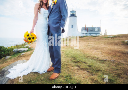 USA (Maine), Bristol, Low section de couple marié, phare en arrière-plan Banque D'Images