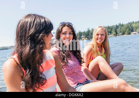 USA, Washington, Bellingham, Jeunes femmes hanging out by lake Banque D'Images