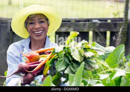 Portrait of senior woman holding carottes et betteraves Banque D'Images