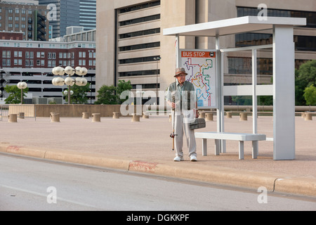 États-unis, Texas, Dallas, Senior homme debout à l'arrêt de bus avec la canne à pêche Banque D'Images