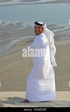 En costume traditionnel qatari avec gutra, en face de la plage de Khor Al Udeid, Khor El Deid, Mer Intérieure, desert miracle du Qatar Banque D'Images