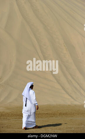 En costume traditionnel qatari avec gutra, en face de la plage de Khor Al Udeid, Khor El Deid, Mer Intérieure, desert miracle du Qatar Banque D'Images