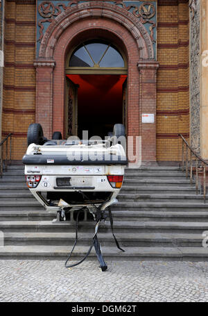 L'art et la culture, vieux-accident voiture endommagée tourné à l'envers, devant l'entrée de l'Altes Postfuhramt building, Berlin Banque D'Images