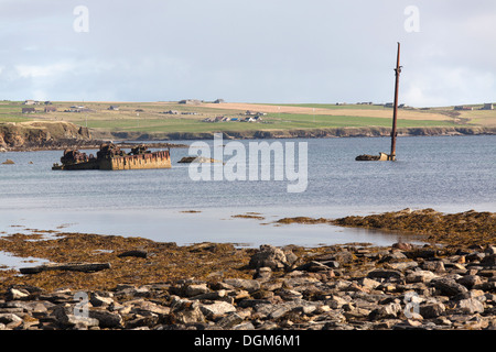 Des îles Orcades, en Écosse. L'Orkney avec son Skerry blockships engloutie et l'île de Lamb Holm en arrière-plan. Banque D'Images