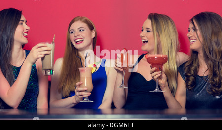 Attractive friends clubbing holding cocktails Banque D'Images