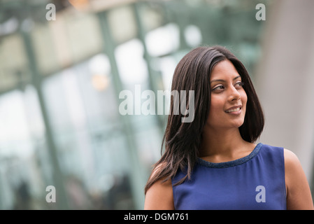 Les gens d'affaires. Une femme avec de longs cheveux noirs portant une robe bleue. Banque D'Images