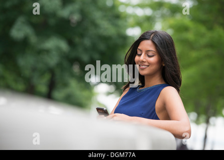 Les gens d'affaires. Une femme avec de longs cheveux noirs portant une robe bleue. Banque D'Images