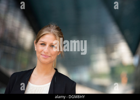 Une jeune femme blonde sur une rue de la ville de New York. Portant une veste noire. Banque D'Images