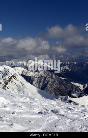 Montagnes ensoleillées dans des nuages, vue à partir de la pente de hors-piste. Montagnes du Caucase, la Géorgie, ski de Gudauri. Banque D'Images