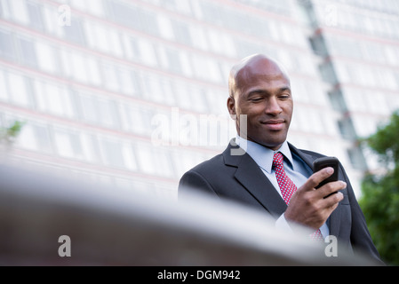 Les gens d'affaires. Un homme en costume de vérifier son téléphone. Banque D'Images