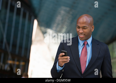 Les gens d'affaires. Un homme en costume de vérifier son téléphone. Banque D'Images