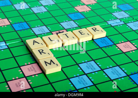 Scrabble lettres formant les mots arm et de modifier, de l'allemand pour être pauvre dans la vieillesse Banque D'Images